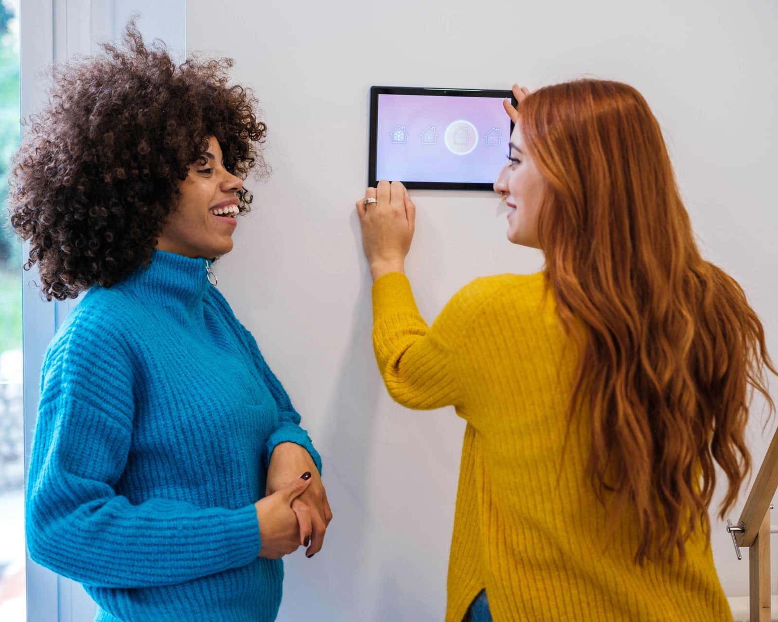 Two women setting up a smart home control panel