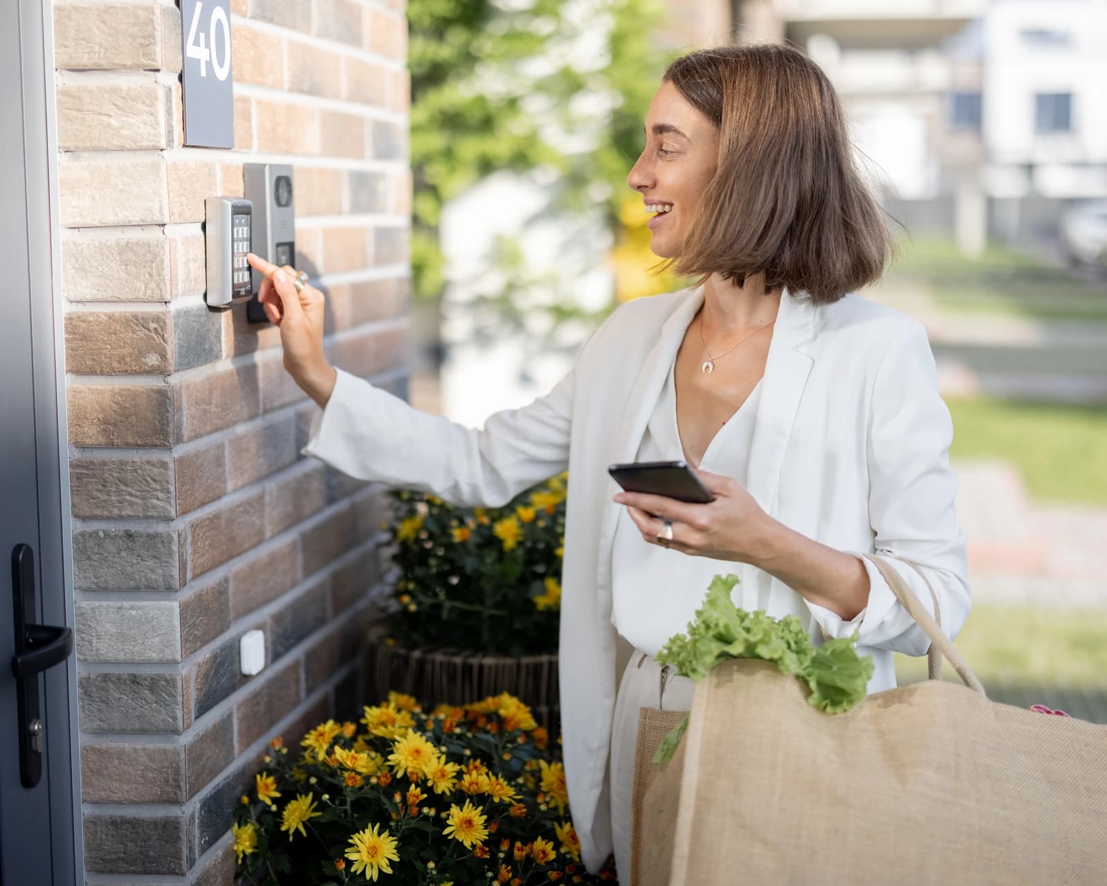 Woman entering a code on a smart door keypad to access her home