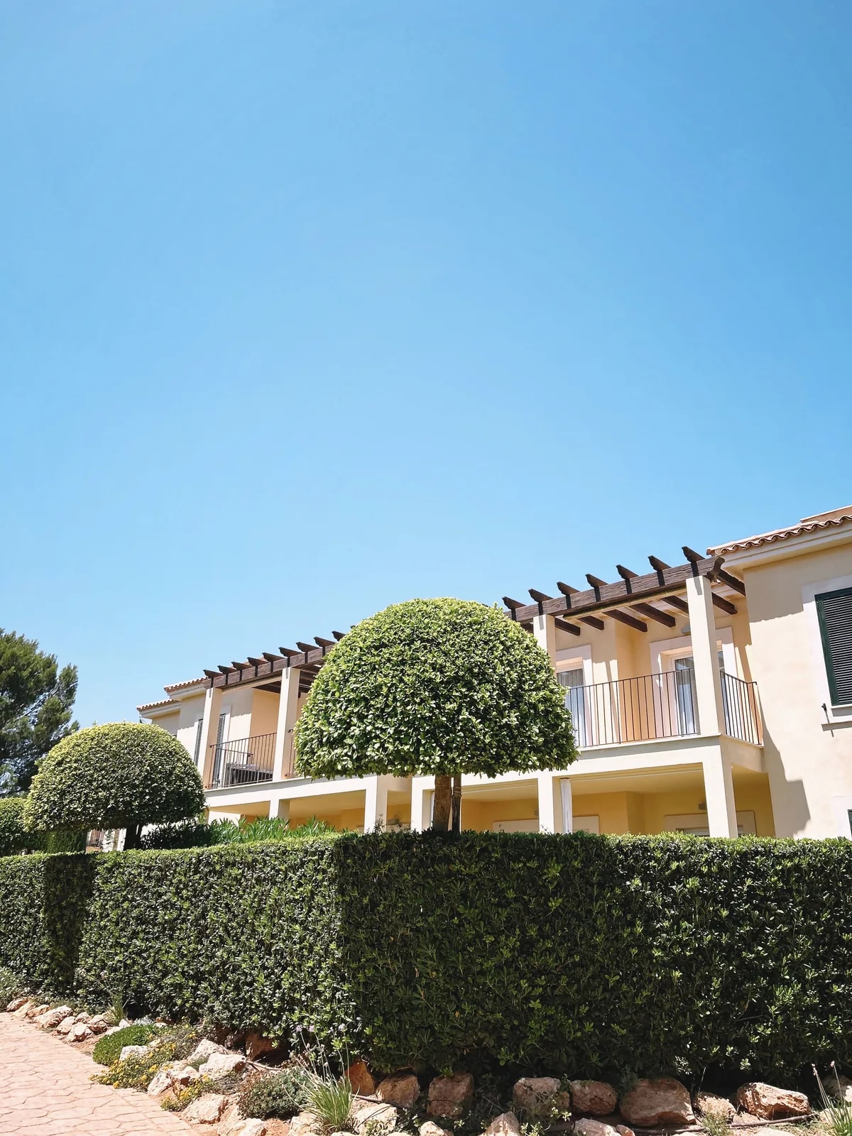Cream house with pergolas and topiary, like the Mediterranean-style villas of Al Reef we automate