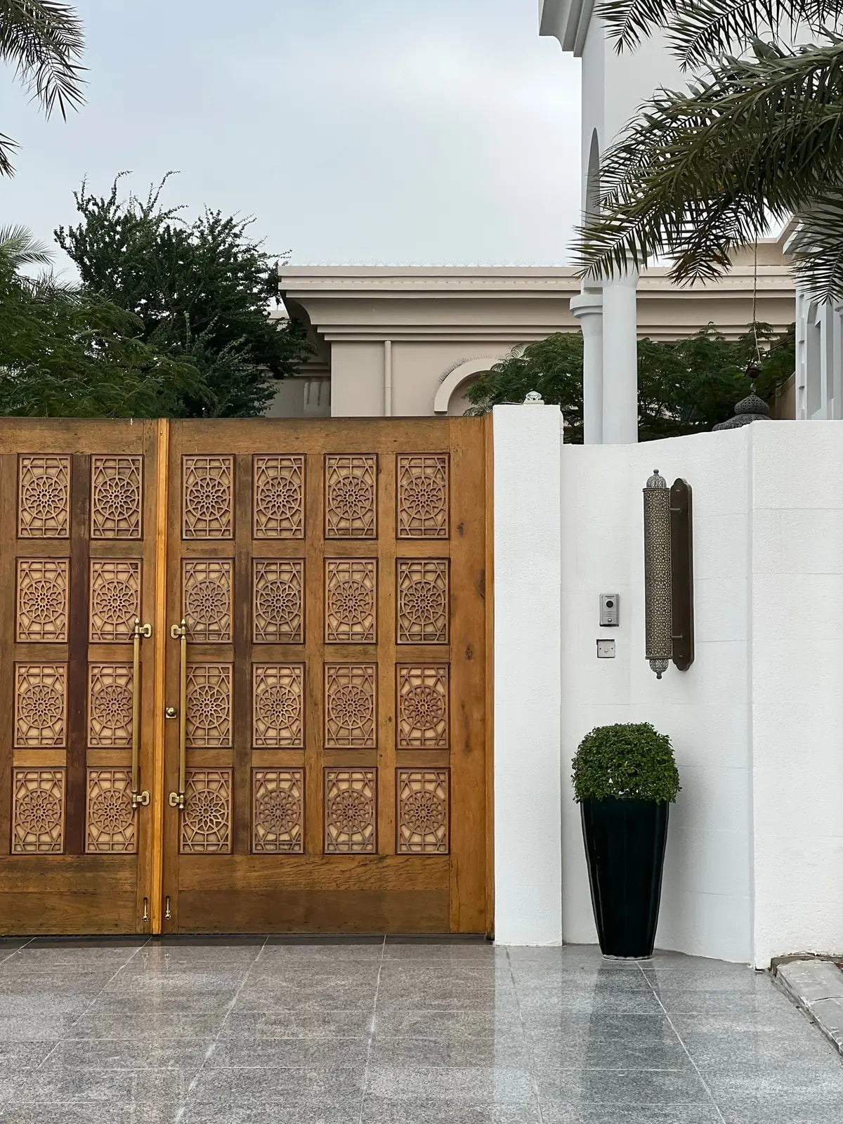 A carved wooden villa gate with an intercom, like the family villas of Mohammed Bin Zayed City we automate