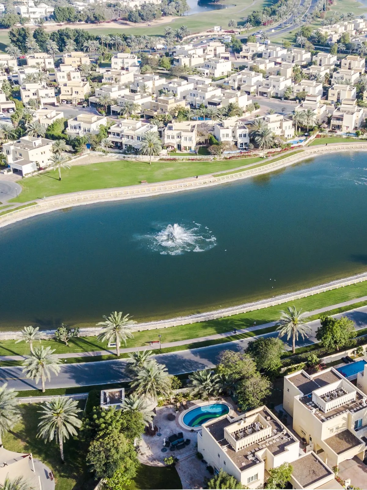 Aerial view of Meadows 7 villas around a lake in The Meadows, Dubai, where we design home automation
