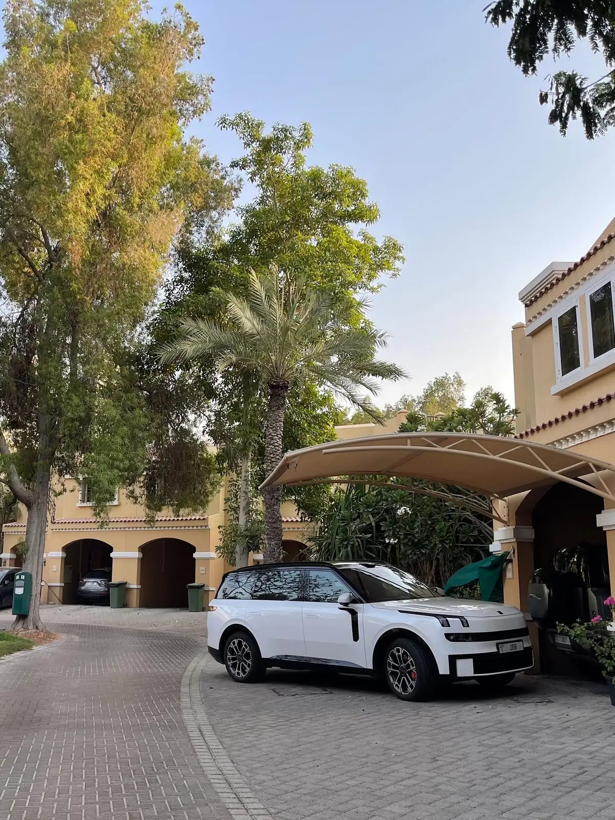 Mediterranean-style compound villa with a carport and tall palms, like the Al Barsha 1 villas we automate