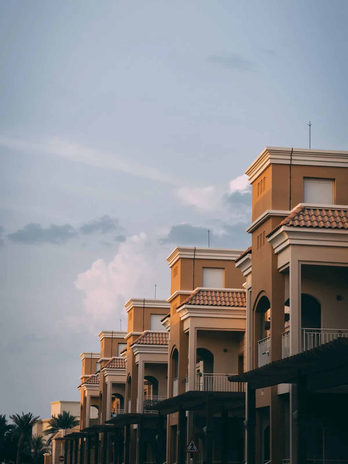 Mediterranean-style townhouses with terracotta roofs and arched balconies, like the Al Furjan townhouses we automate