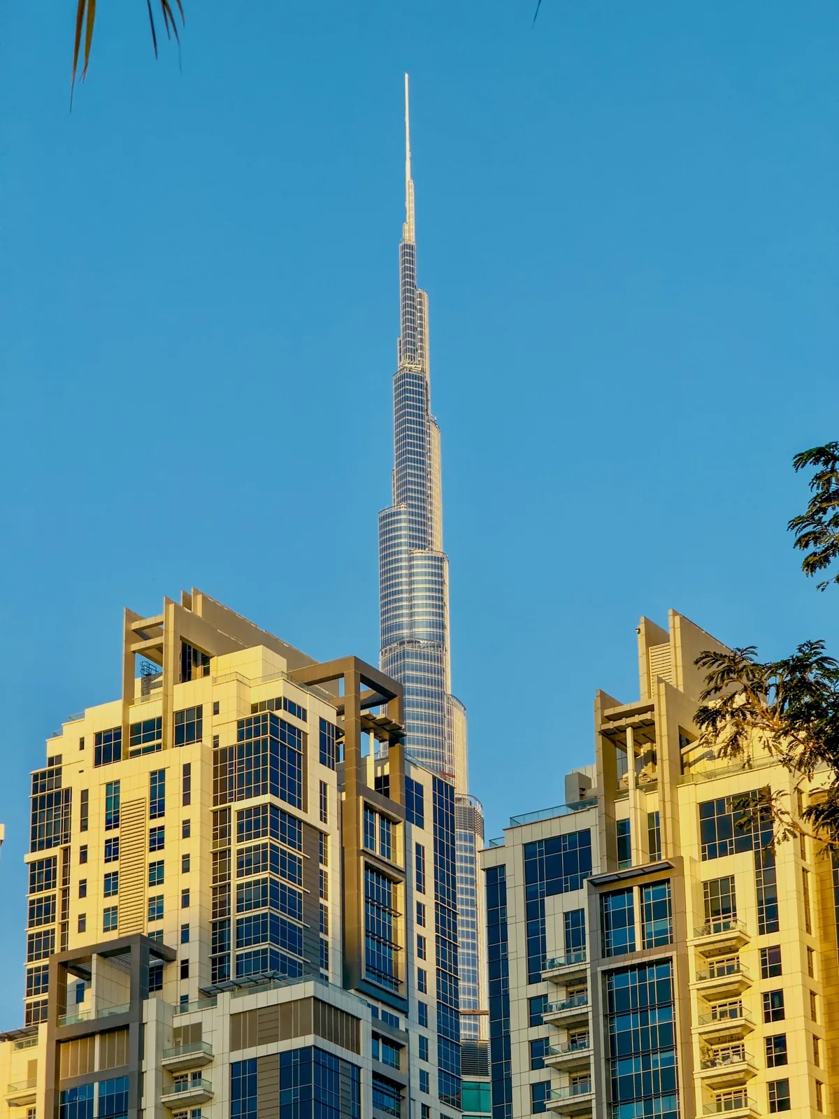 Burj Khalifa rising between Downtown Dubai apartment towers, where we design home automation for flats and penthouses