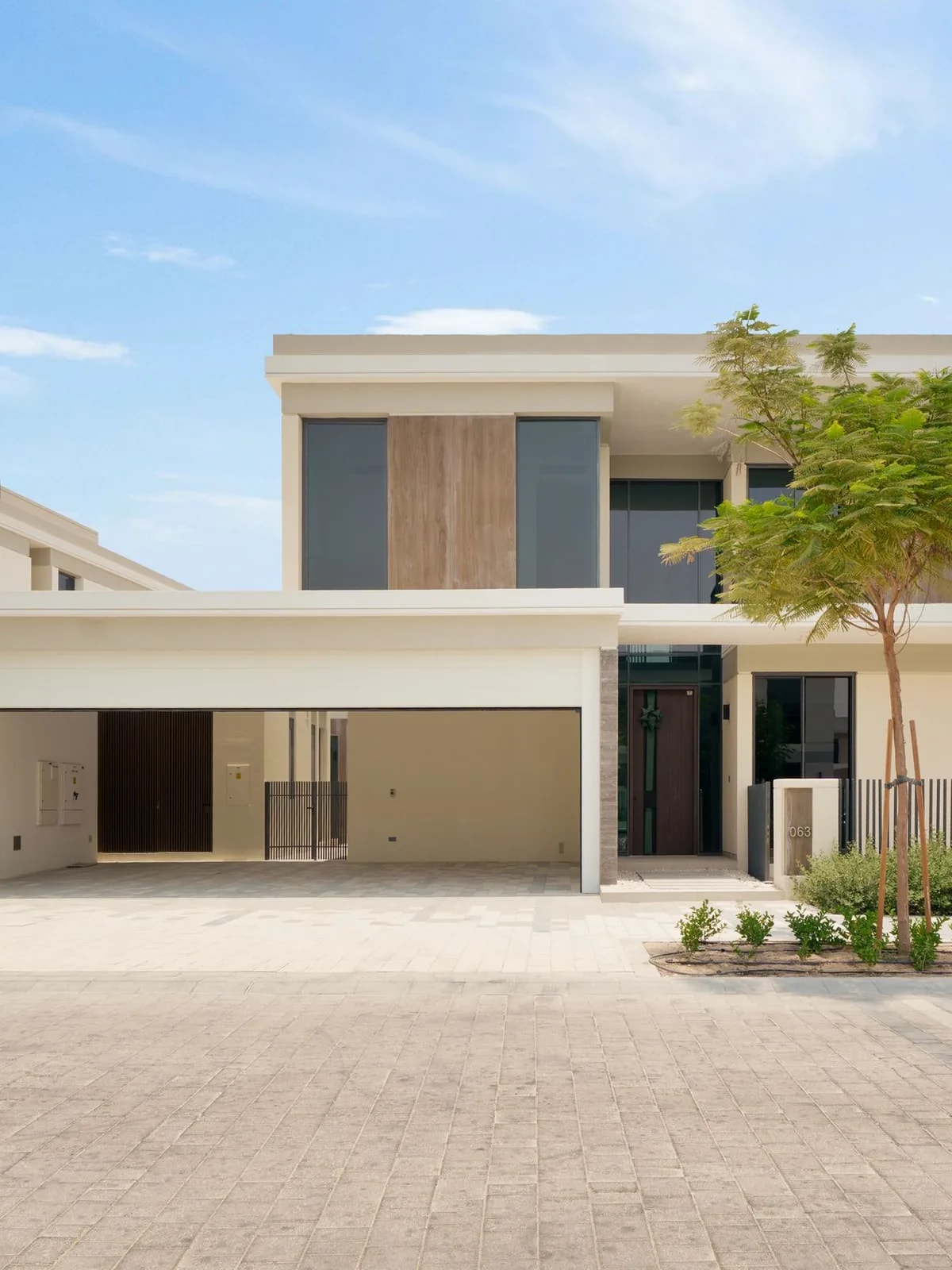 Contemporary two-storey cream villa with a paved driveway, like the Dubai Hills Estate villas we automate