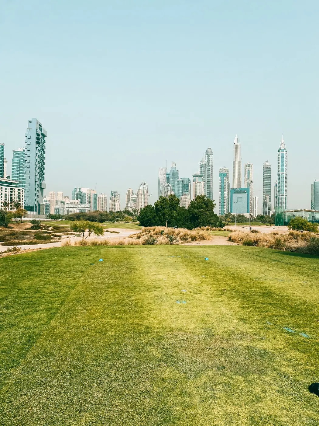Golf fairway at Emirates Golf Club with the Marina skyline, beside the Emirates Hills mansions we automate