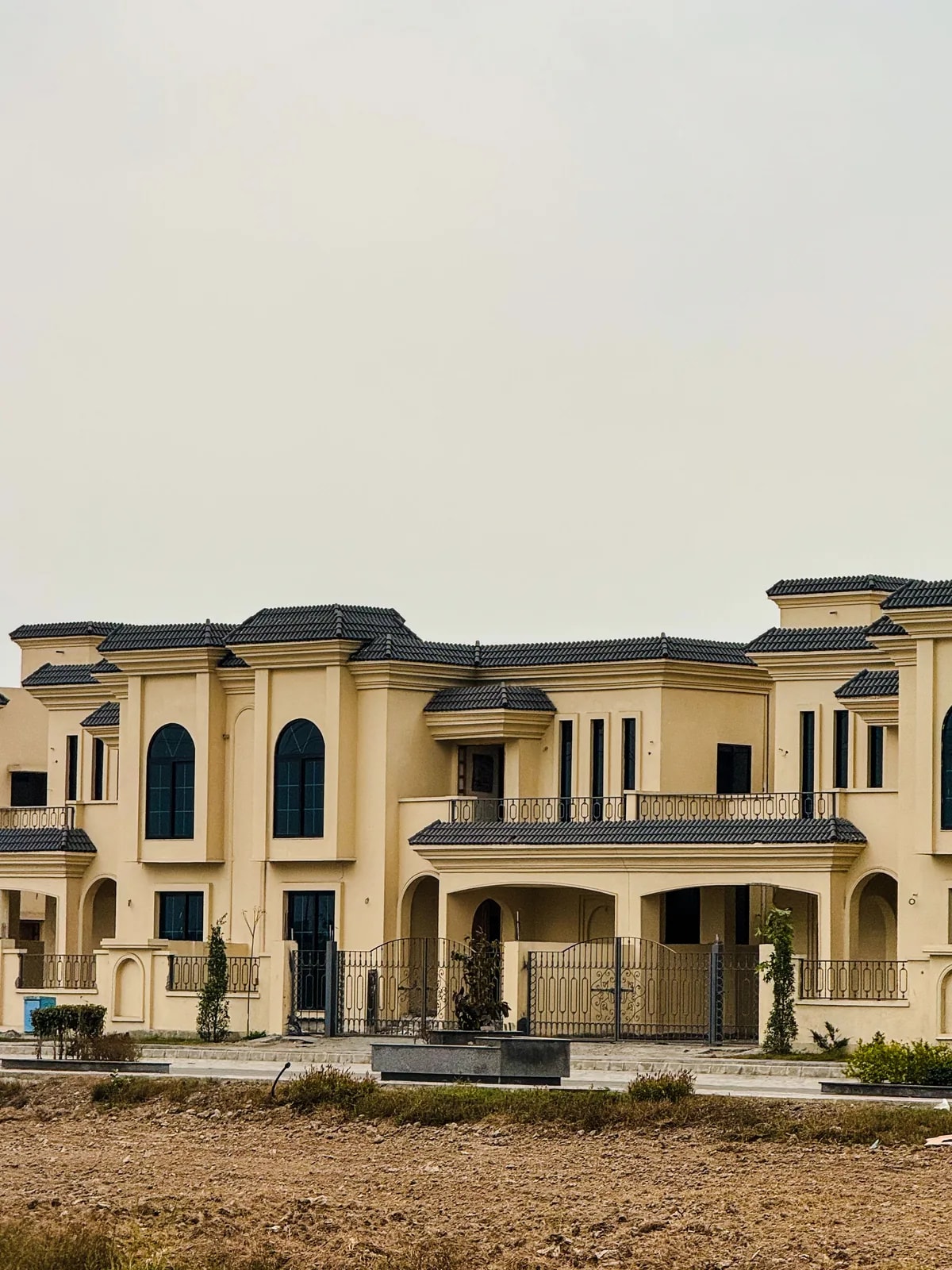 Beige two-storey villa with arched windows, like the family villas of Khalifa City A we automate
