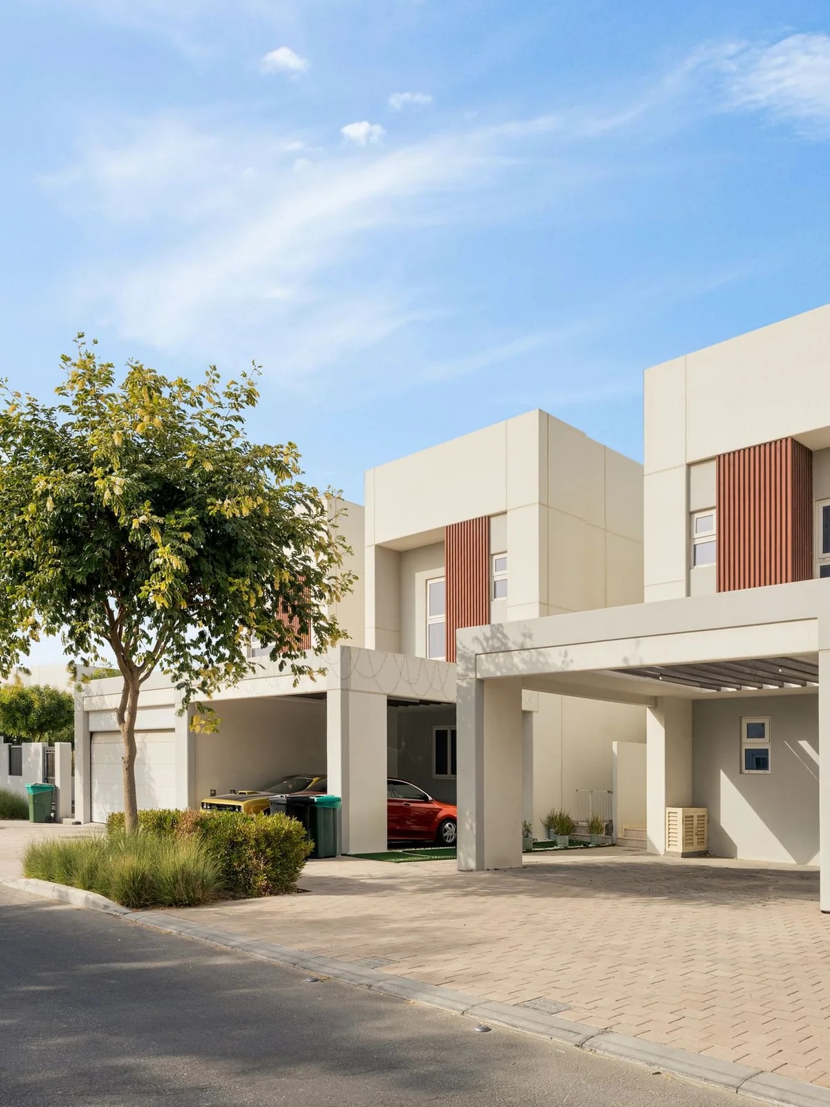 Cream two-storey townhouses with dark red panels and carports, like the Mudon townhouses we automate