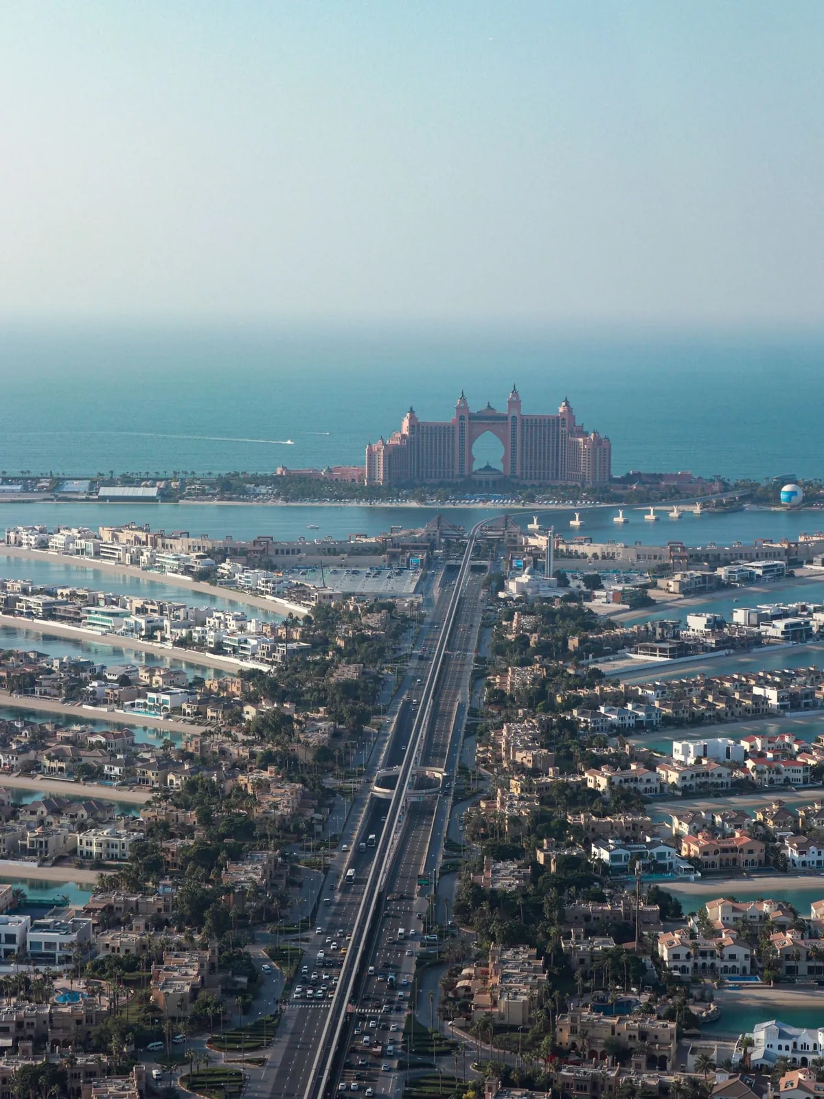 Aerial view of the Palm Jumeirah Trunk and fronds leading to Atlantis, homes we automate