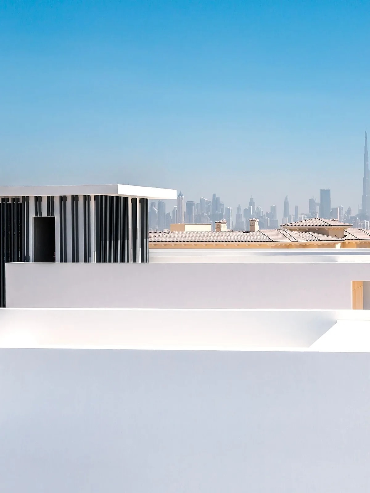 White townhouse rooftops with the Dubai skyline behind, like the Town Square Dubai townhouses we automate