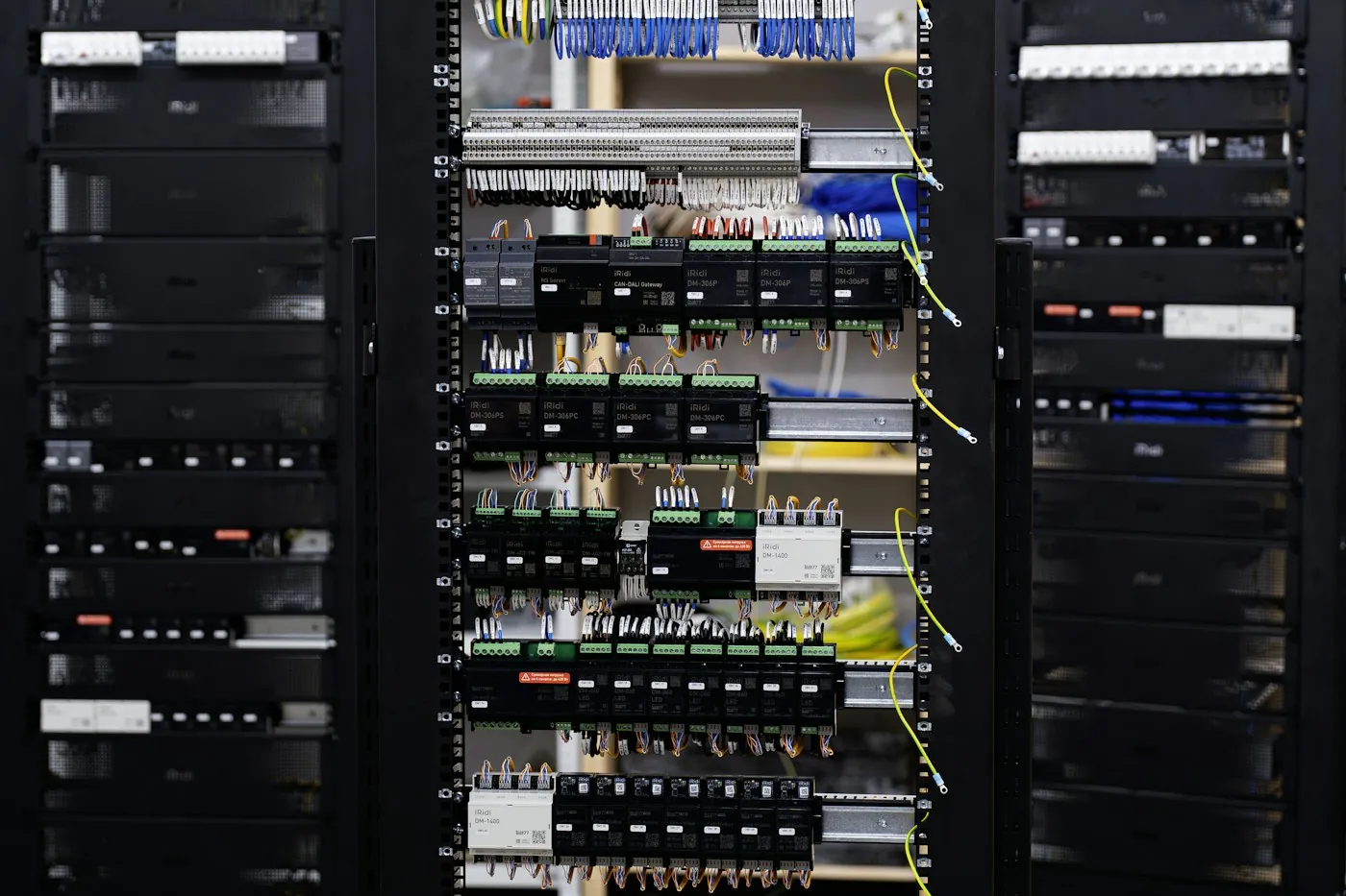 Open home-automation control cabinet with wiring, relays and gateway modules mounted on DIN rail