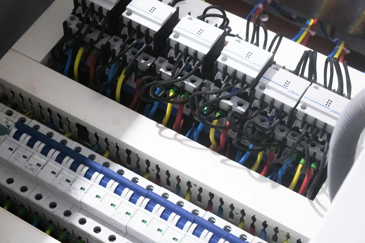 Distribution board with rows of DIN-rail modules and circuit breakers, wired with colour-coded cables