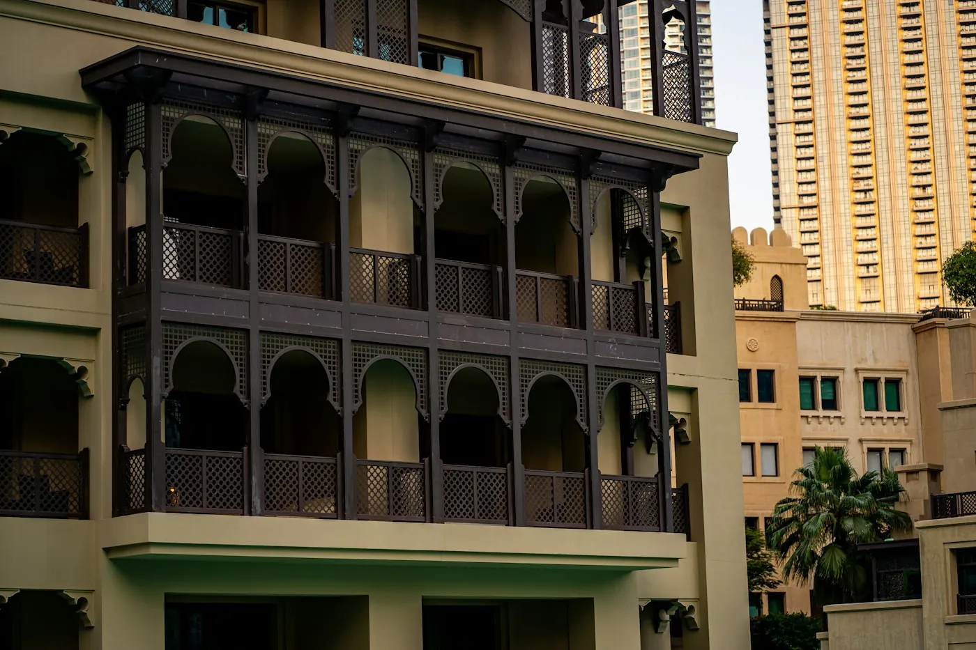 Traditional Arabesque balconies on a low-rise Dubai building with a modern high-rise tower behind it