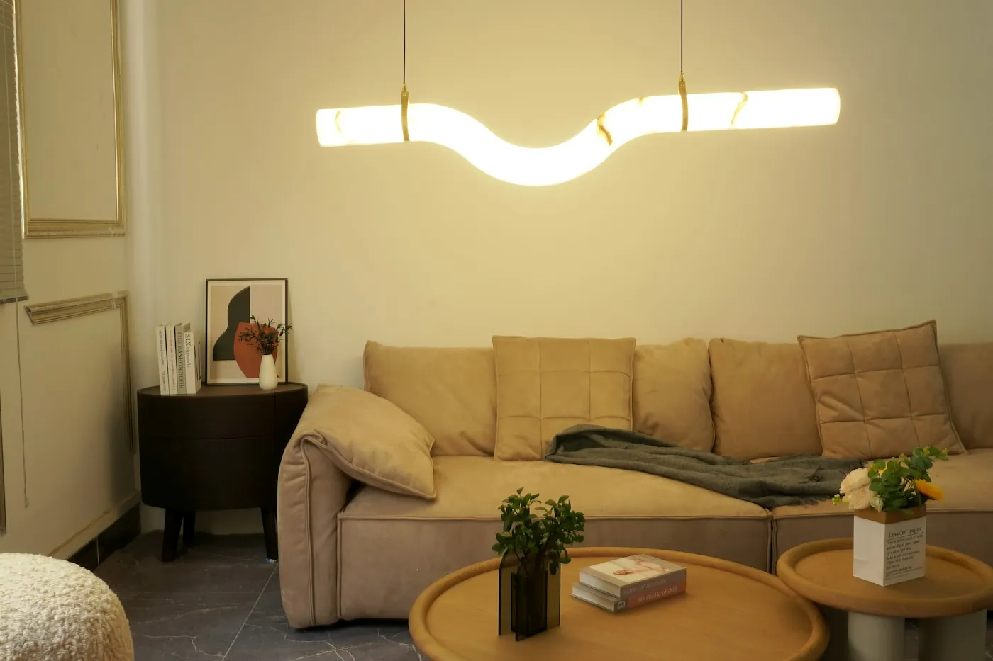 Cosy living room corner with a sofa lit by a warm pendant lamp