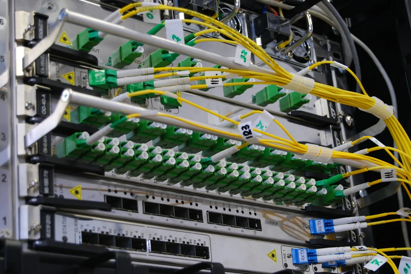 Organised fibre and cable termination panel with labelled patch cords in a comms rack