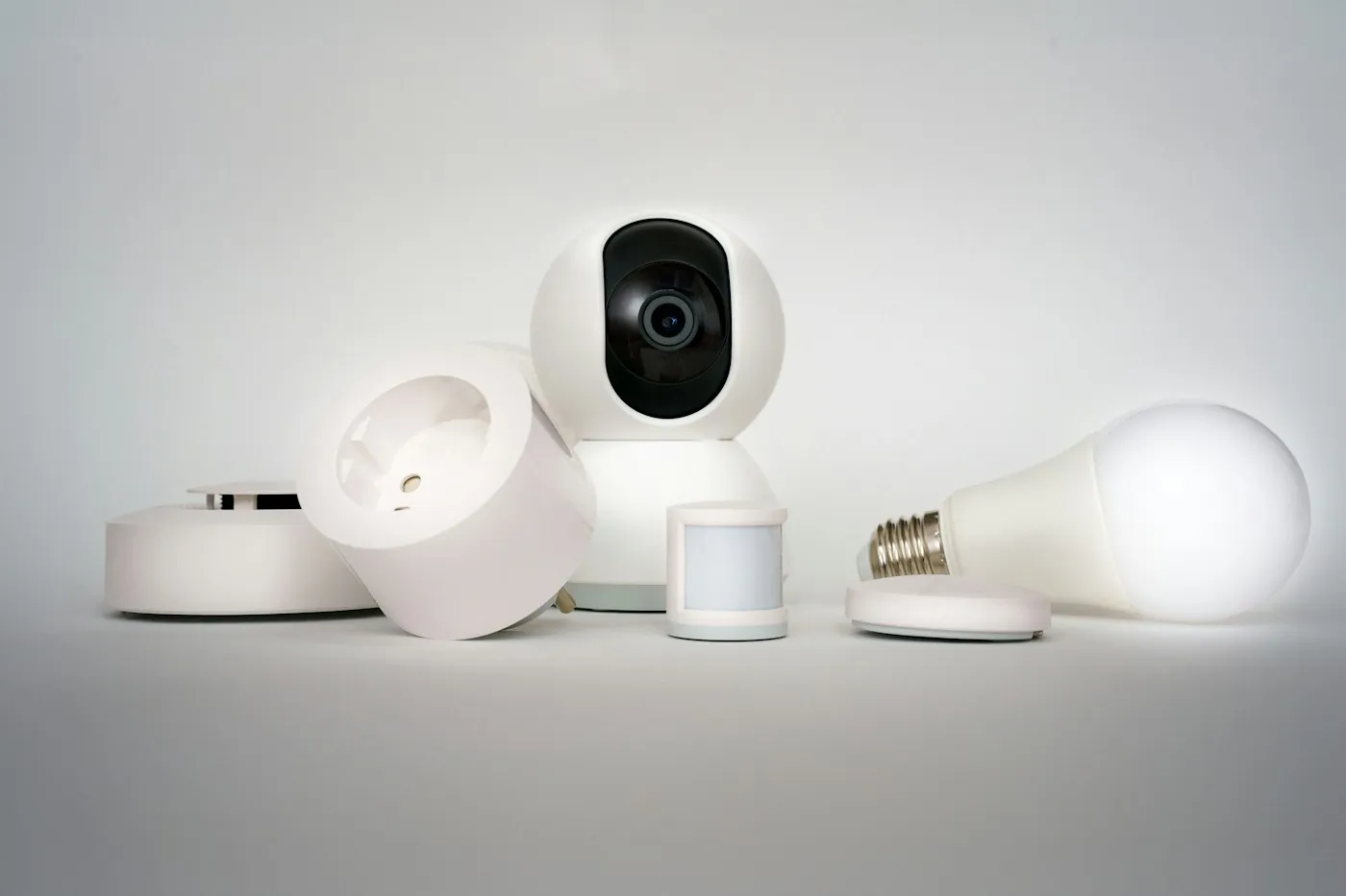 Lineup of smart home devices: a camera, smart plug, motion sensor and bulb