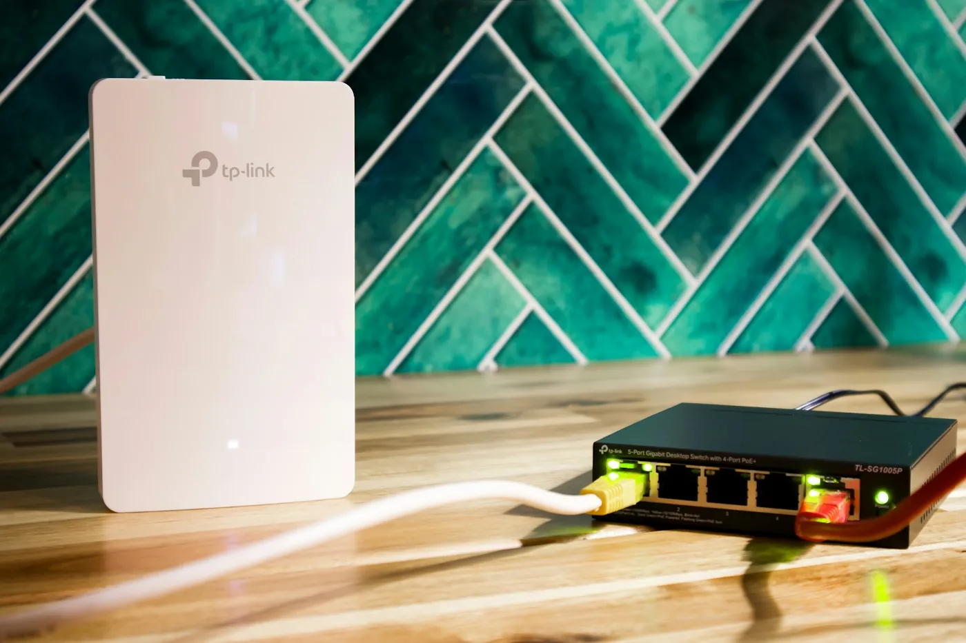 A wall-mounted wireless access point wired to a network switch on its own cable run